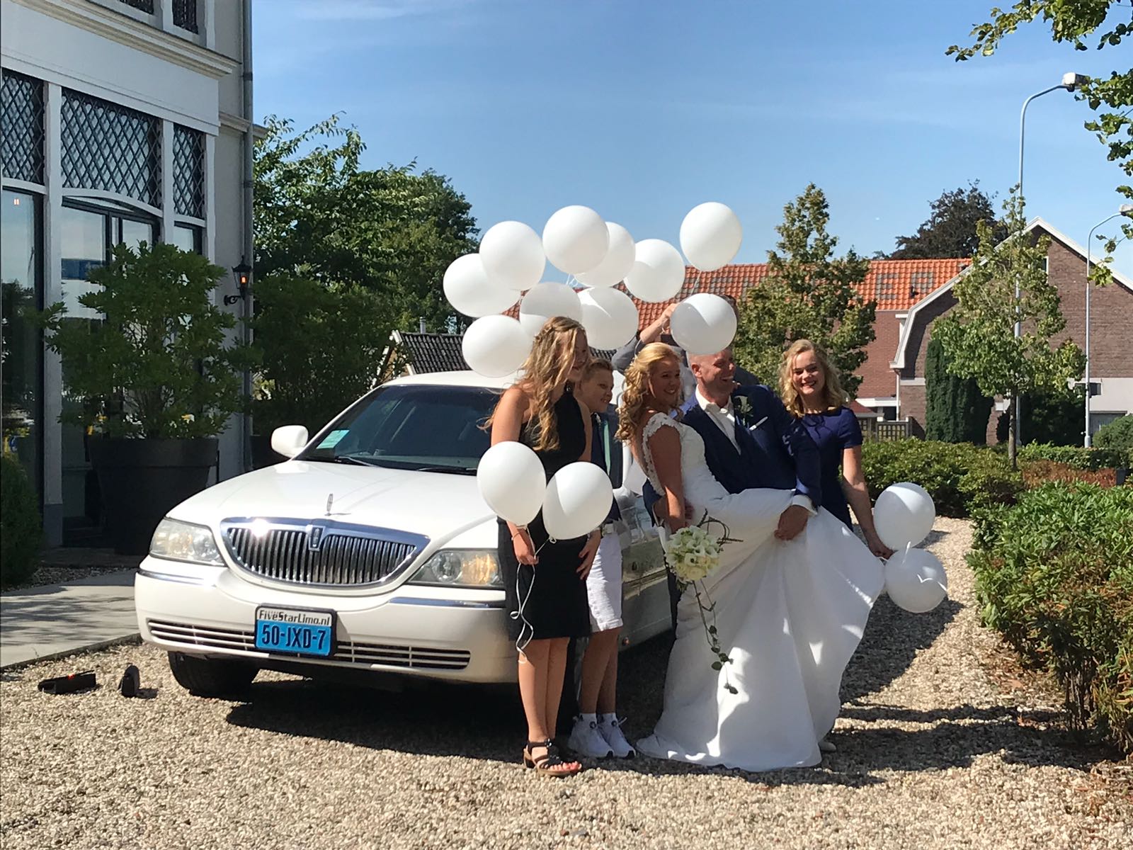 Wedding celebration with balloons and limousine.