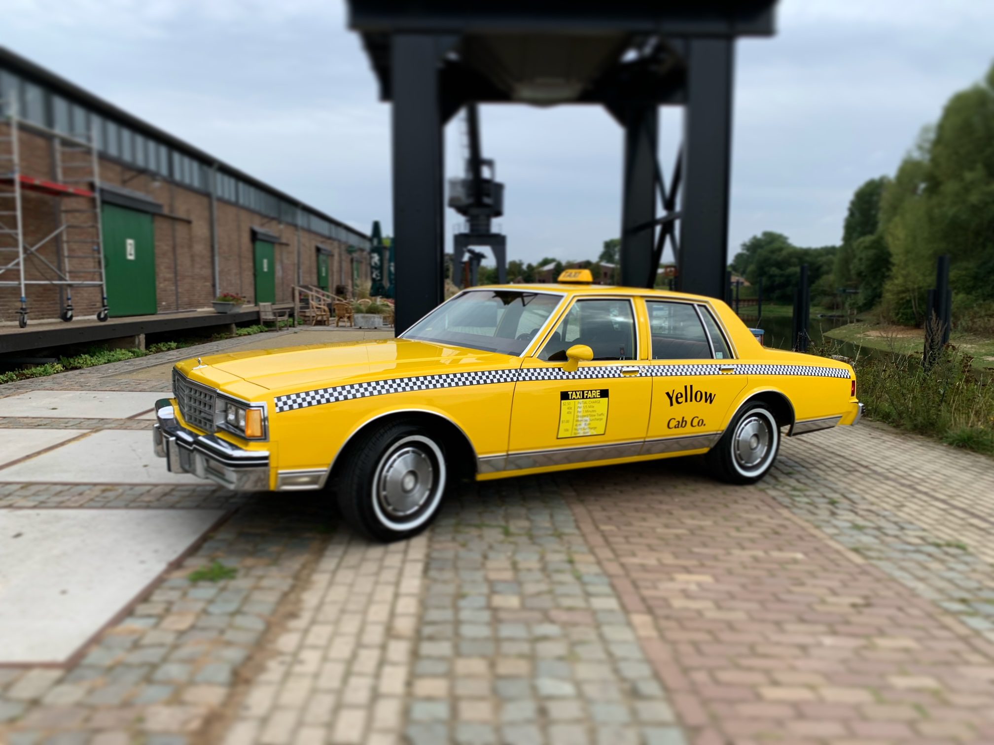 Classic yellow taxi parked outdoors.