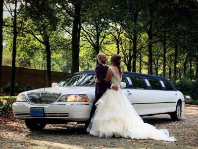 wedding couple in front of limousine