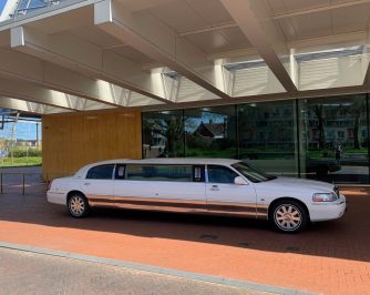 White limousine parked under modern structure
